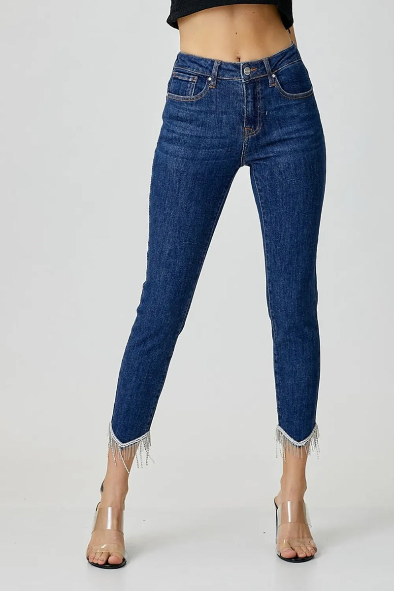 Blue jeans with fringe details on a white background
