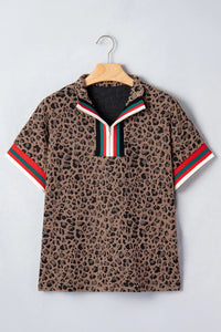 Leopard print polo shirt with red and green stripes on a hanger against a light gray background