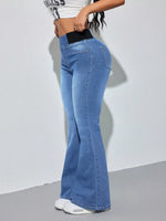 Person wearing blue flared jeans on a plain background