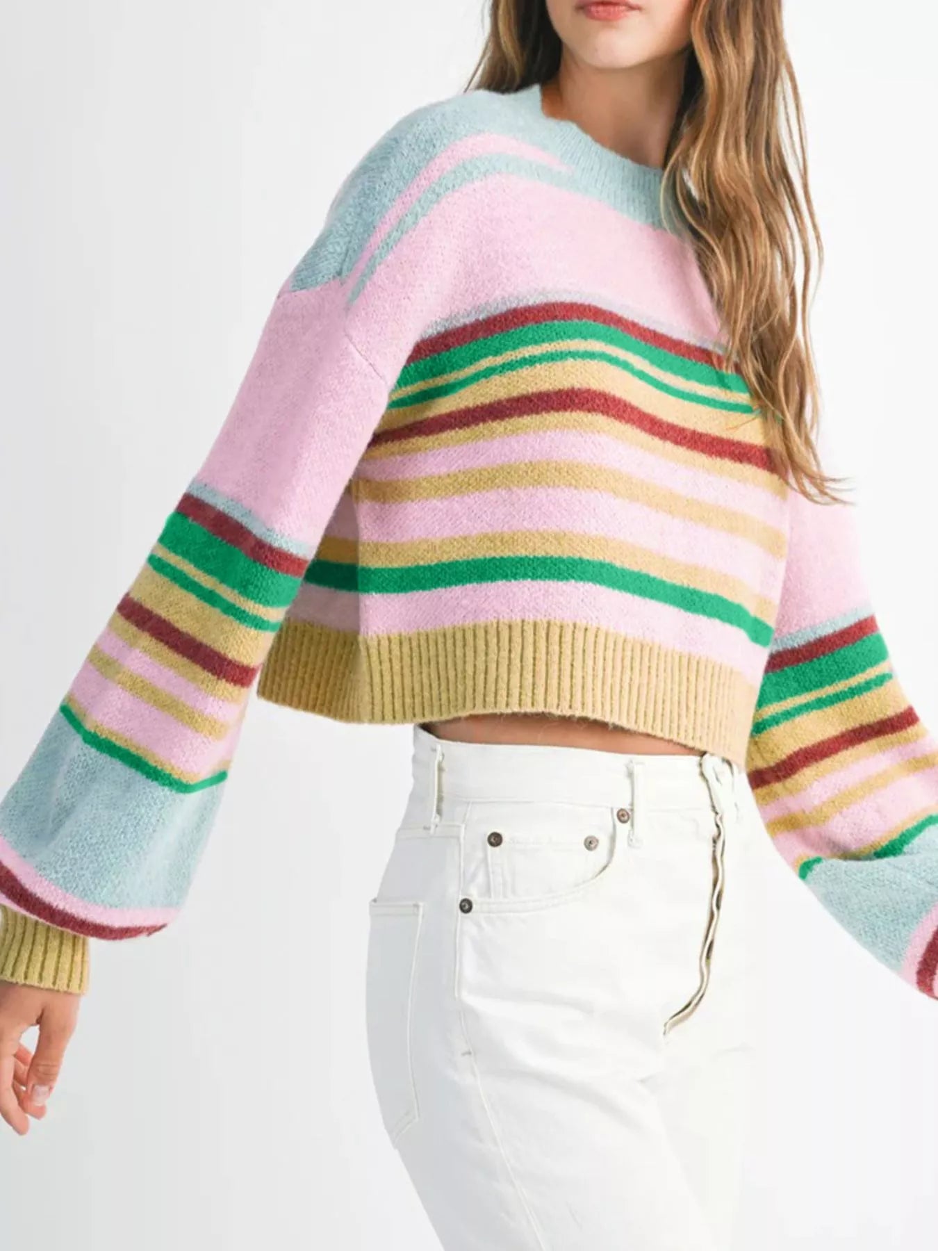 Multicolored striped sweater worn by a person on a white background