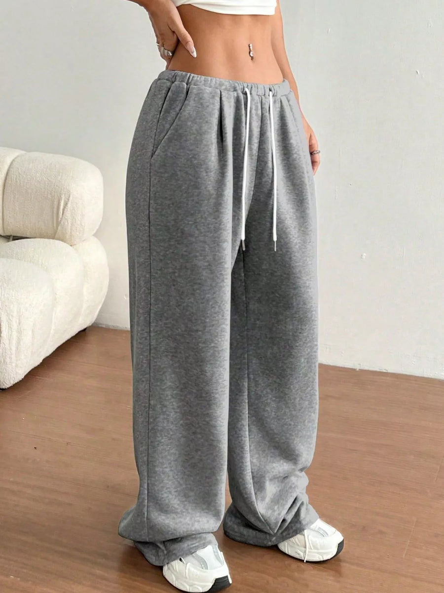 Person wearing gray sweatpants with a white background