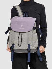 Person wearing a gray and purple backpack with 'Tudor One' branding on a light gray background