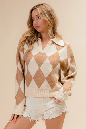 Woman wearing a beige and white argyle sweater with white shorts on a beige background