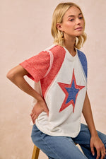 Woman wearing a colorful star-patterned shirt against a beige background