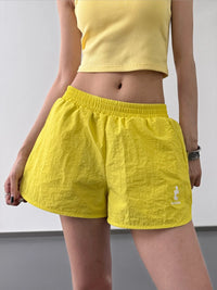 Person wearing yellow shorts and a matching top against a plain background