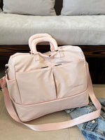 Pink travel bag on a couch with a cushioned seat