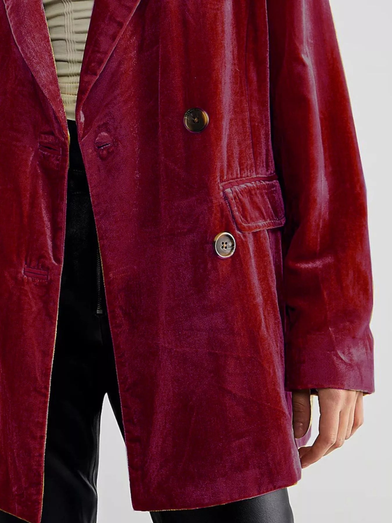 Red velvet coat with gold buttons on a plain background