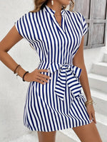 Woman wearing a blue and white striped dress with a white background