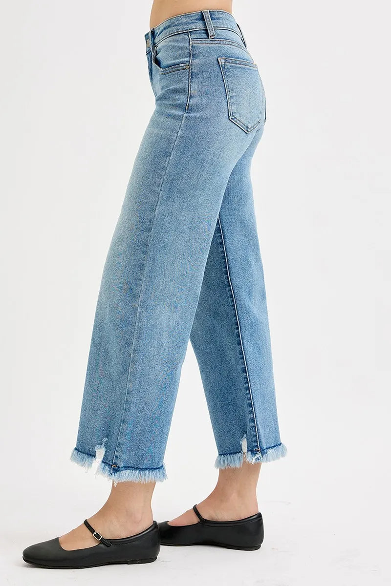 Light blue jeans with frayed cuffs on a white background