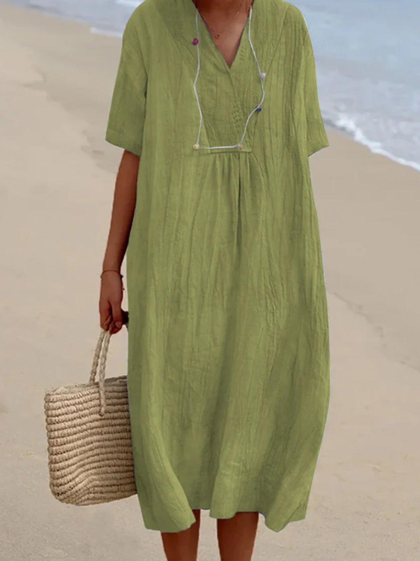 Person wearing a green dress on a beach