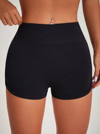 Black high-waisted shorts worn by a person on a light gray background