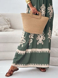Person holding a woven bag wearing a green dress with white patterns.