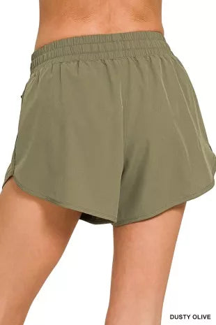 Olive green athletic shorts on a white background
