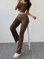 Woman wearing a brown outfit with high-waisted pants and a crop top on a white background
