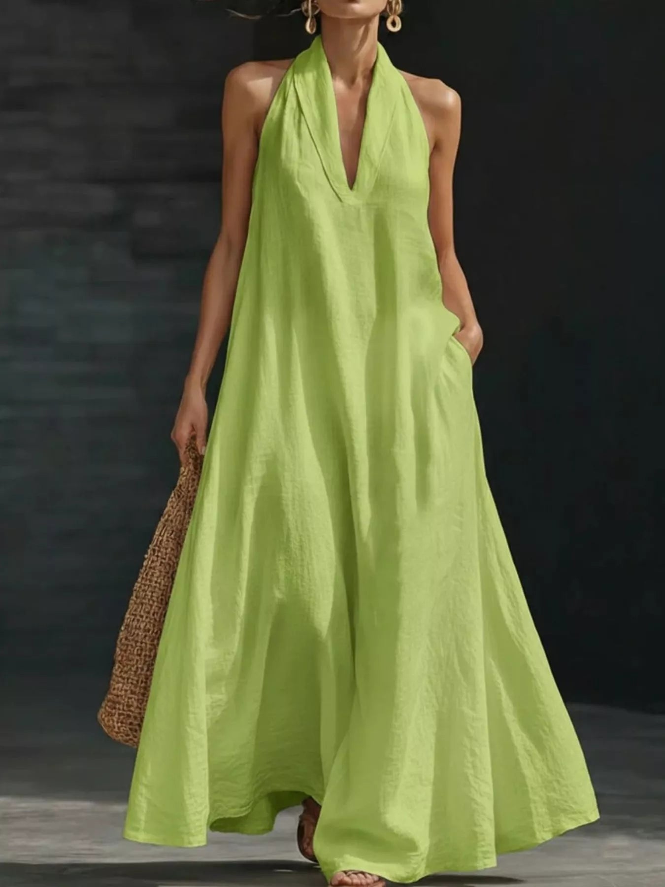 Woman wearing a bright green halter neck dress against a dark background