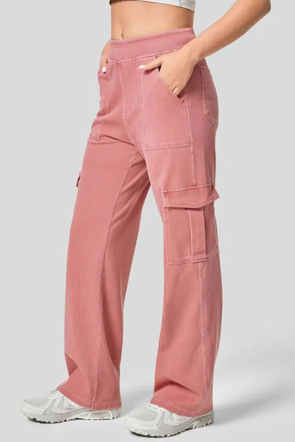 Pink cargo pants worn by a person on a light gray background