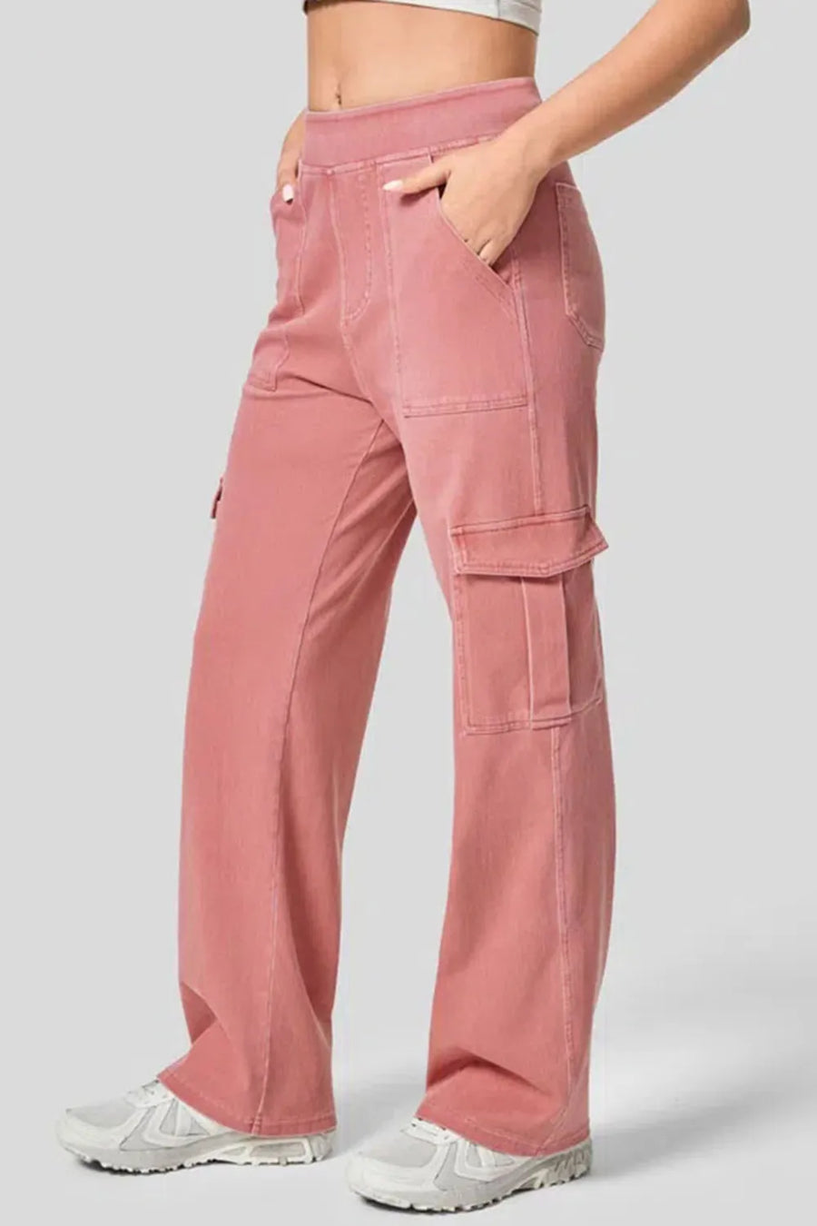 Pink cargo pants worn by a person on a light gray background