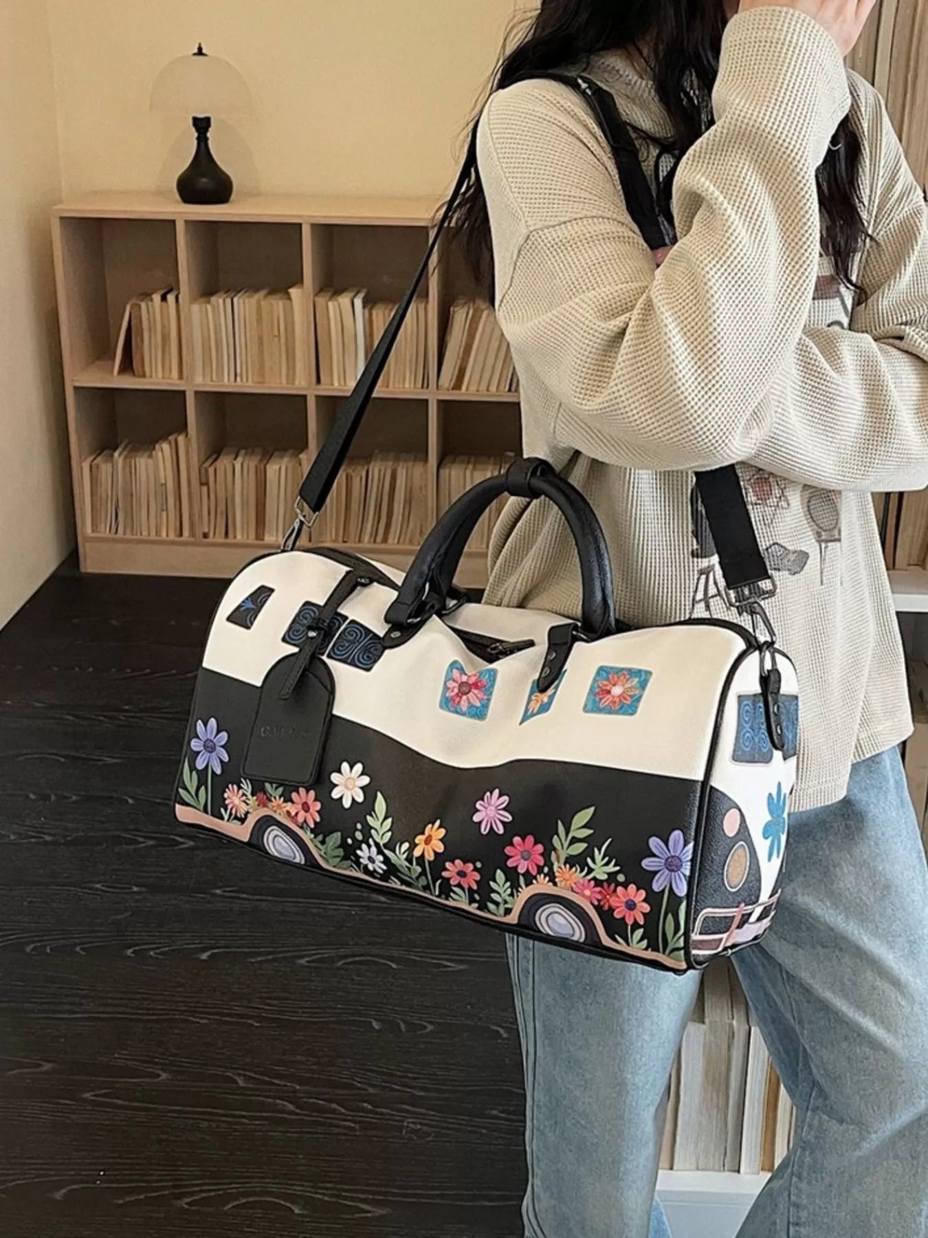Person holding a floral-patterned handbag in an indoor setting