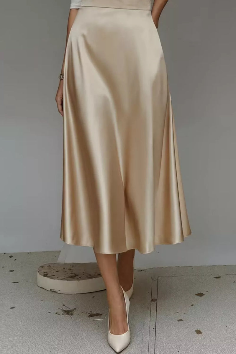 Beige satin skirt worn by a person on a plain background