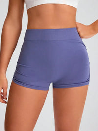 Purple athletic shorts worn by a person on a light gray background