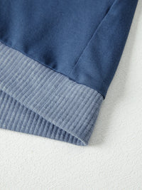 Close-up of a blue fabric with ribbed trim on a white background