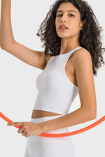 Woman in a white sleeveless top holding an orange hoop against a light gray background
