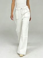 White pants worn by a person on a plain background