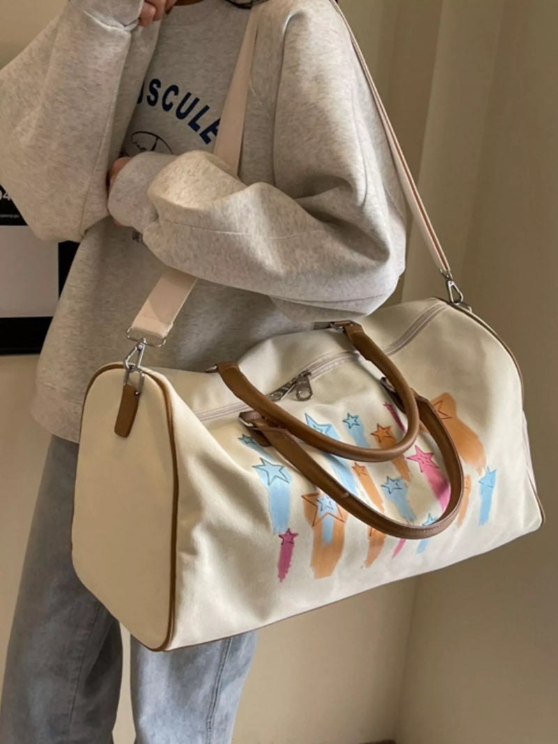 Person holding a beige bag with colorful cat illustrations against a neutral background