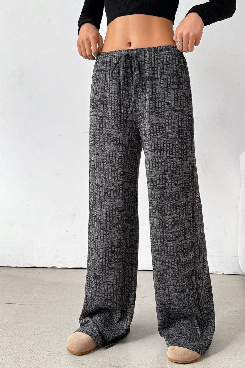 Person wearing gray checkered pajama pants on a white background
