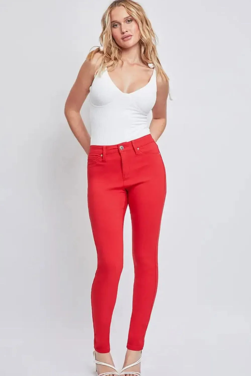 Woman wearing a white top and red pants on a white background