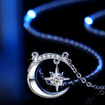 Silver necklace with moon and star pendant on a dark background