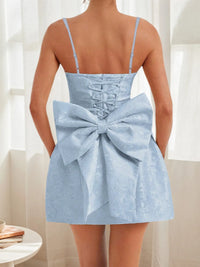 Light blue dress with a large bow detail on the back, worn by a person.