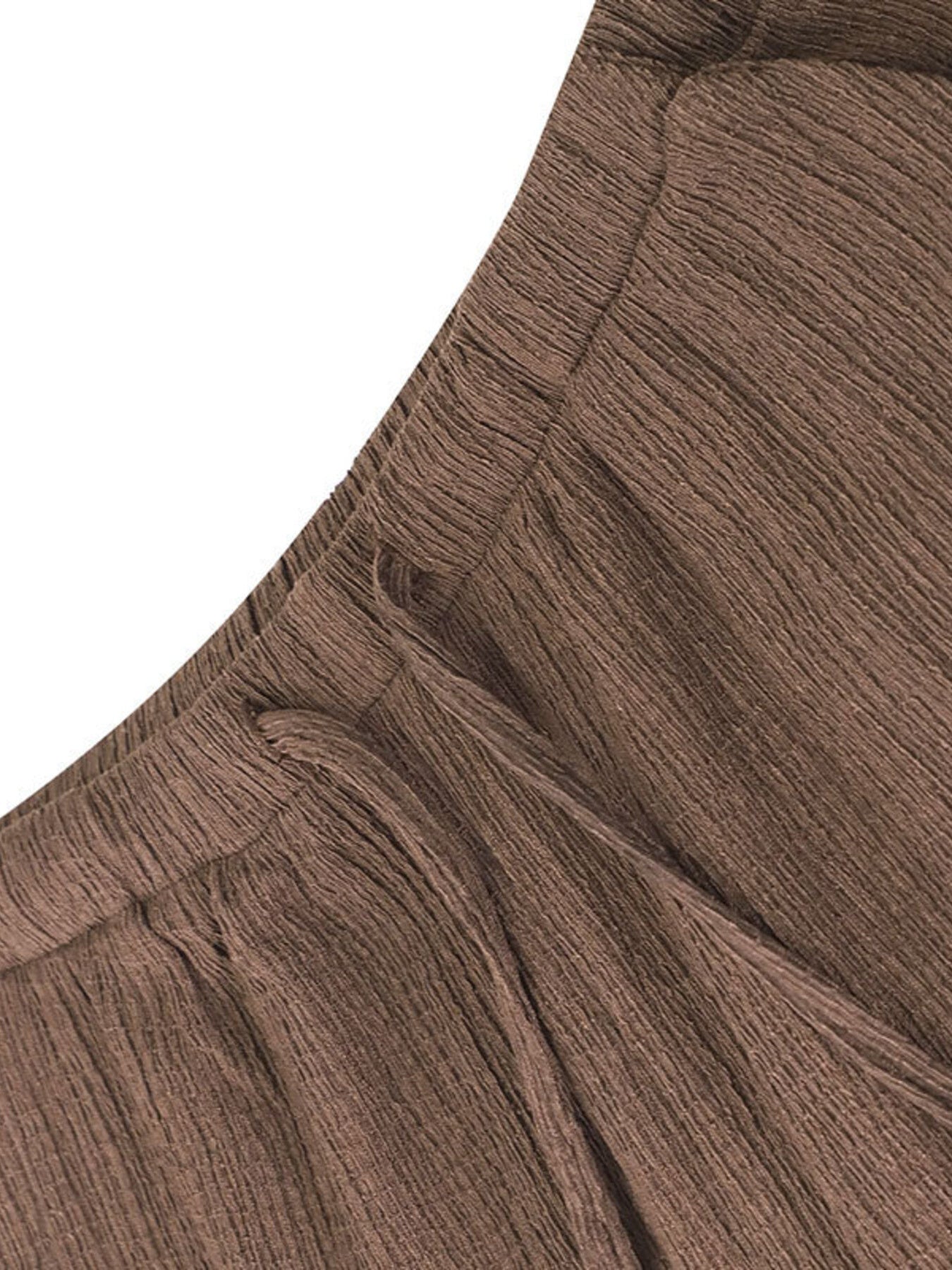 Close-up of brown ribbed knit fabric with a focus on texture and pattern.