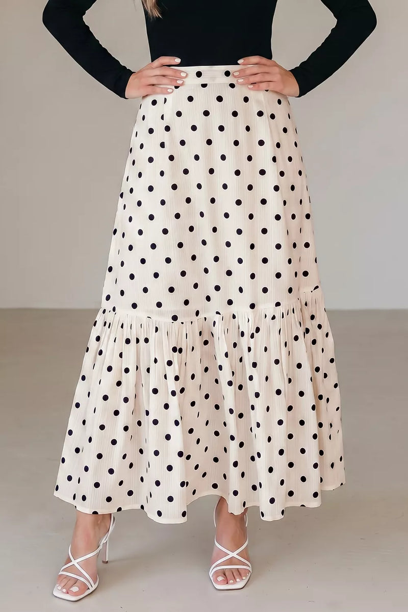 Person wearing a polka dot skirt with a plain background