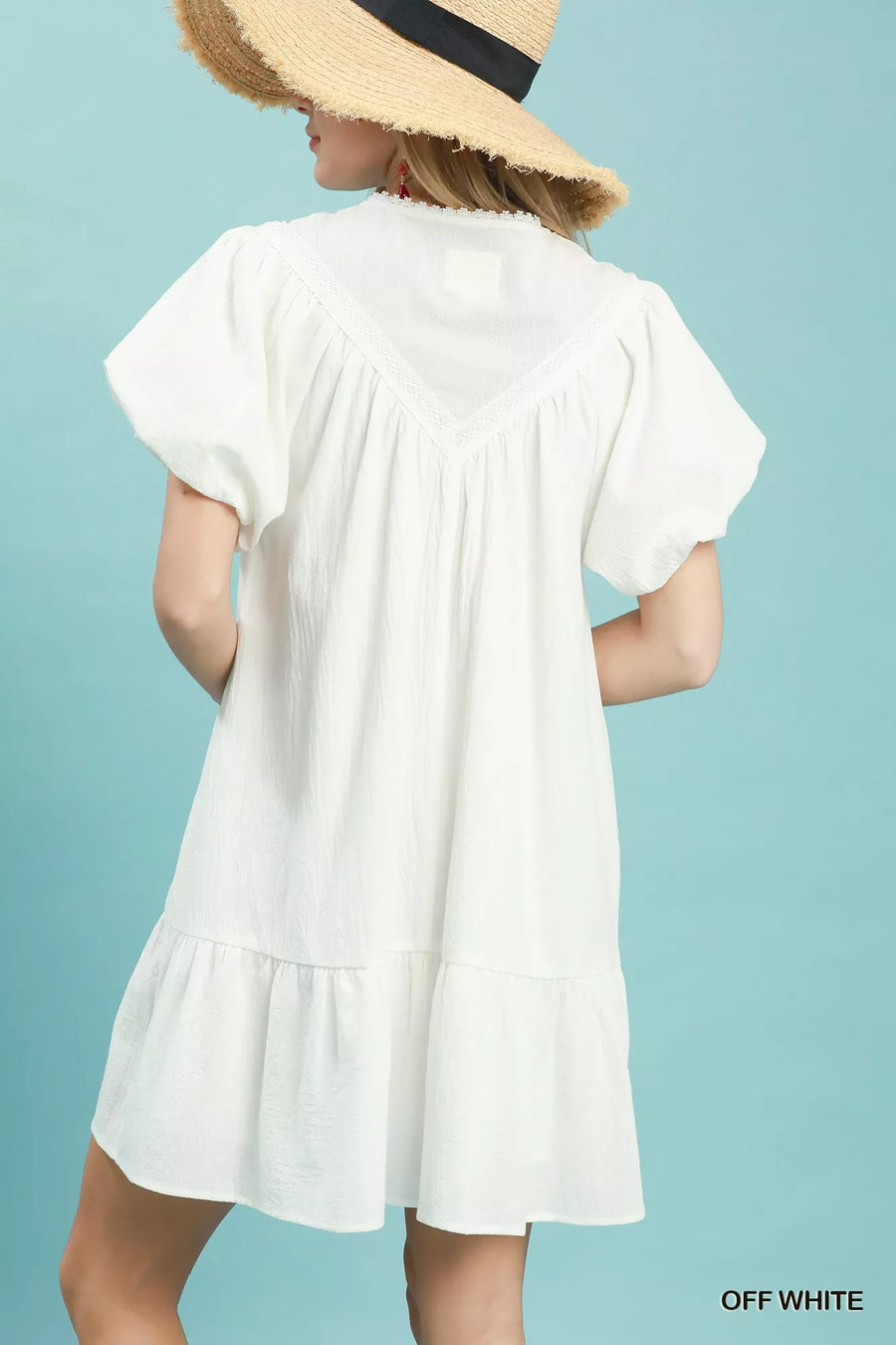 Woman wearing a white dress with a blue background