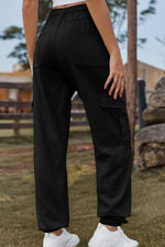 Person wearing black cargo pants with a blurred outdoor background