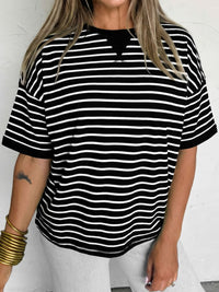 Person wearing a black and white striped shirt on a plain background