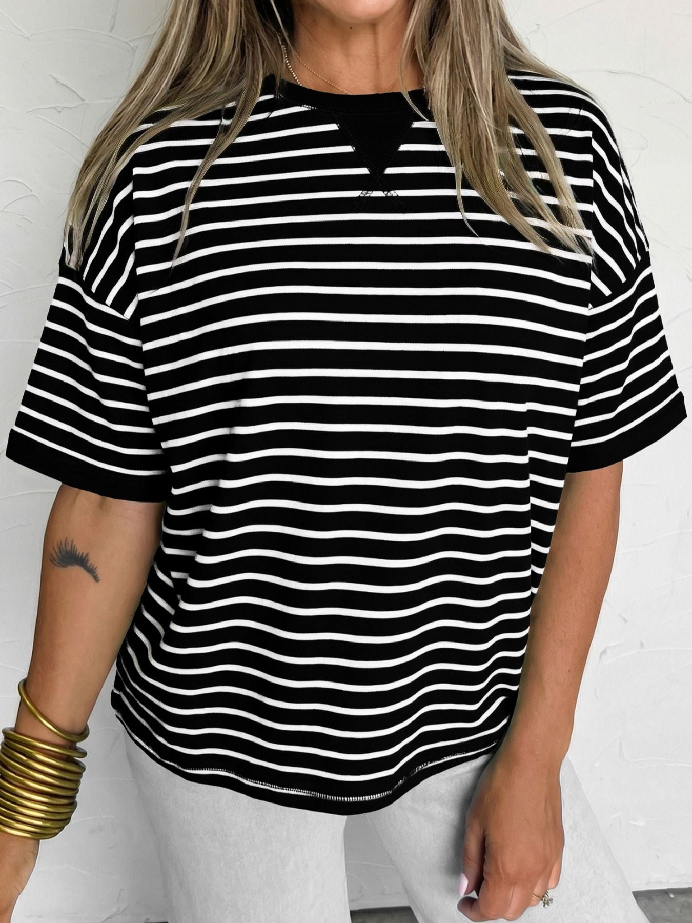 Person wearing a black and white striped shirt on a plain background