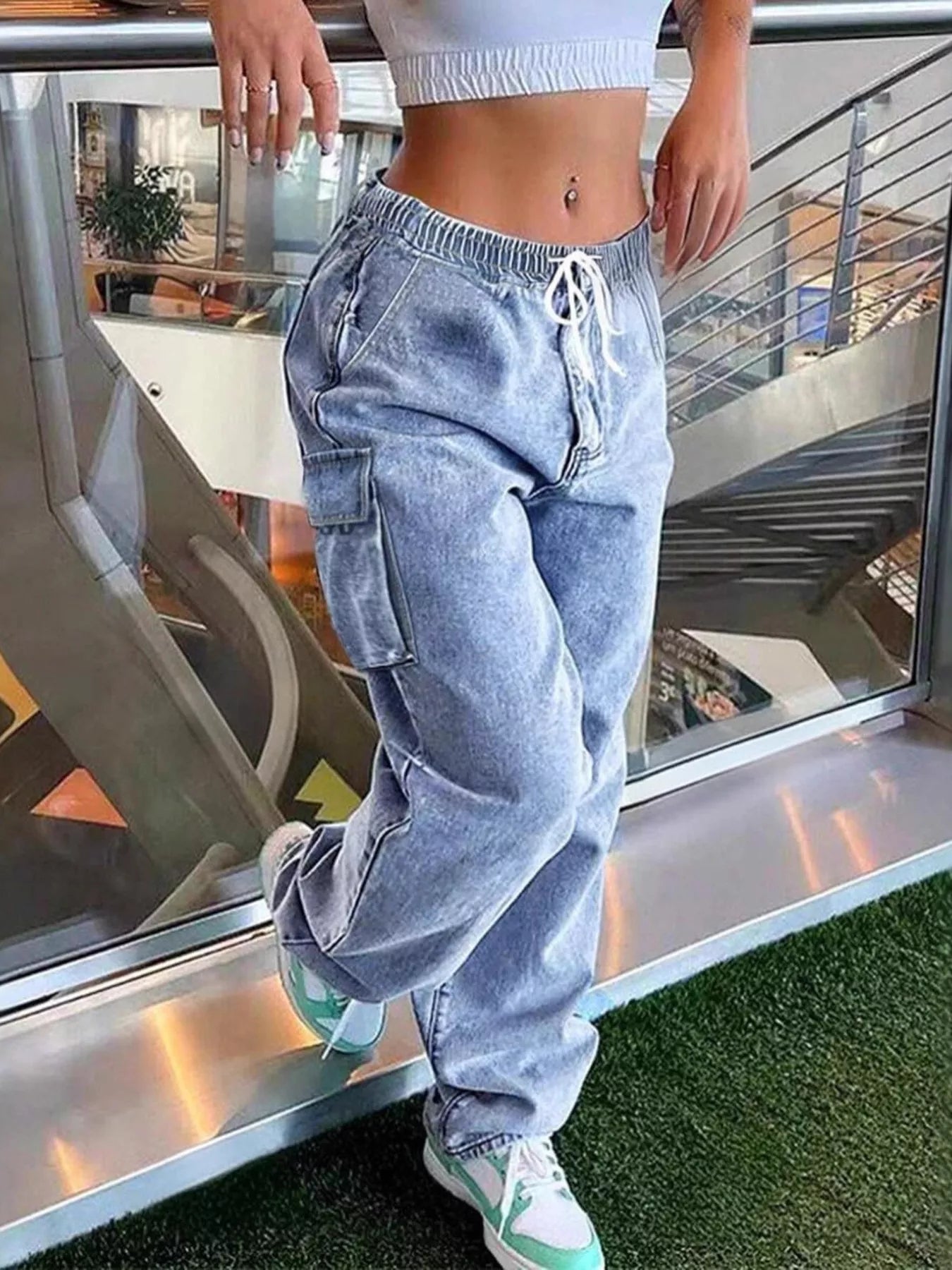 Person wearing light blue cargo pants and white sneakers in an indoor setting.