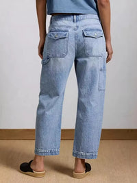 Person wearing light blue jeans on a plain background