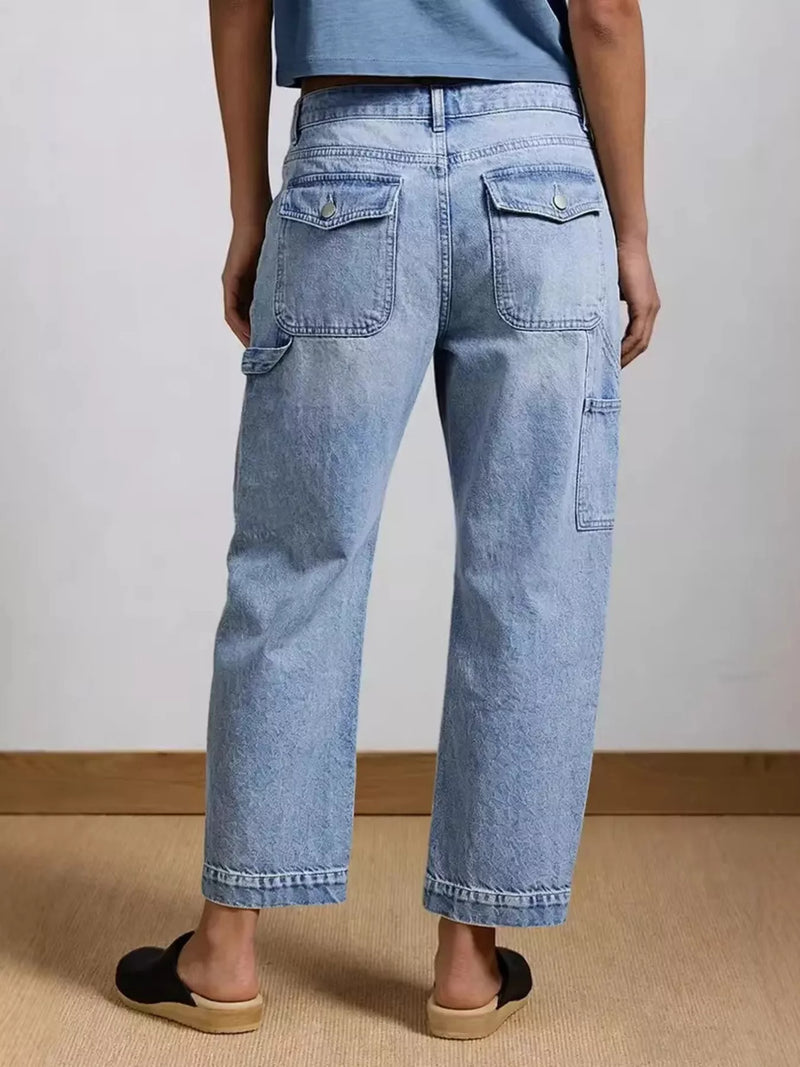 Person wearing light blue jeans on a plain background