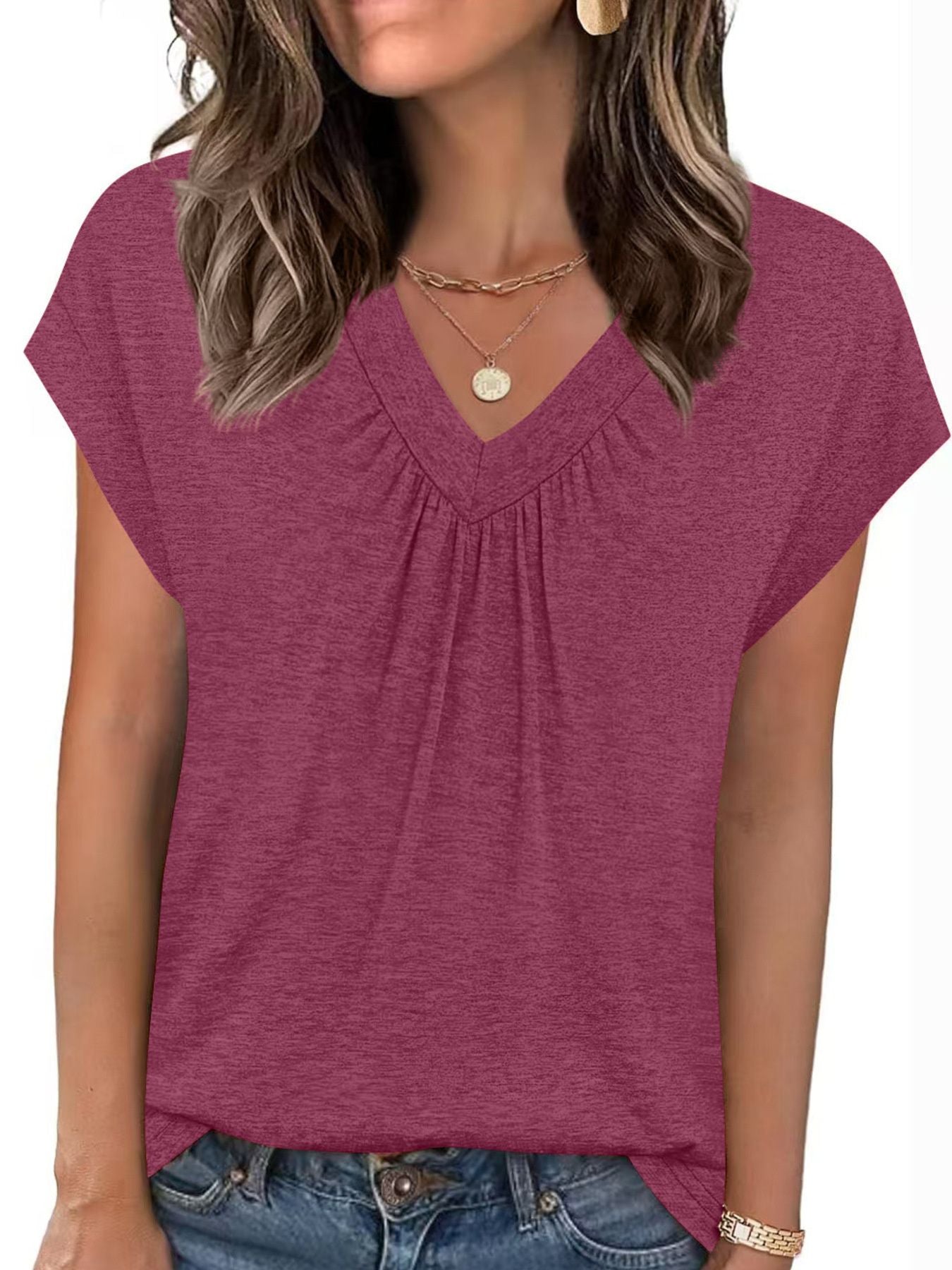 Woman wearing a maroon V-neck t-shirt with short sleeves on a white background