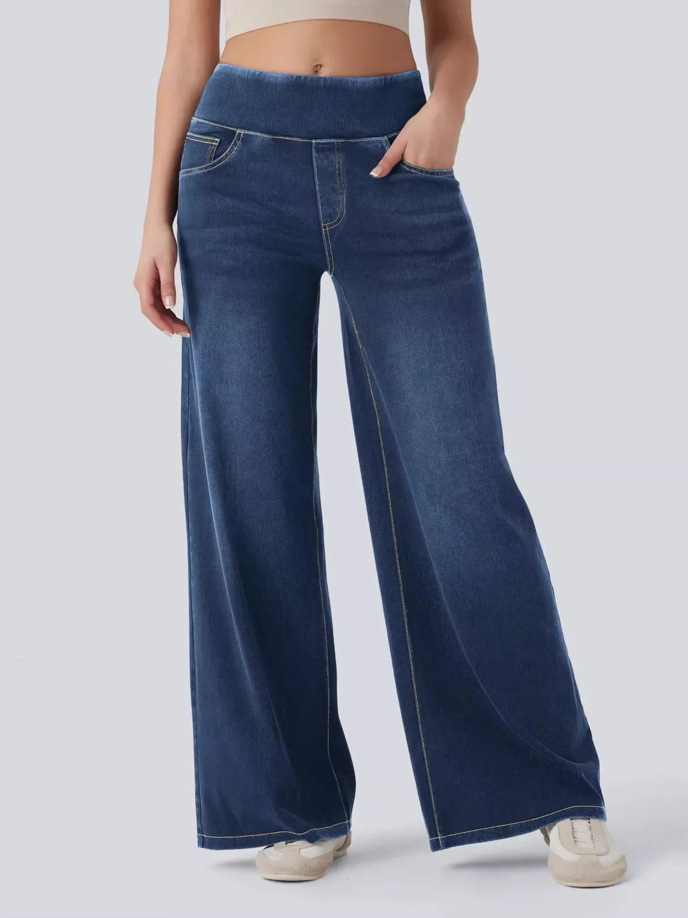 Person wearing blue wide-leg jeans on a plain background