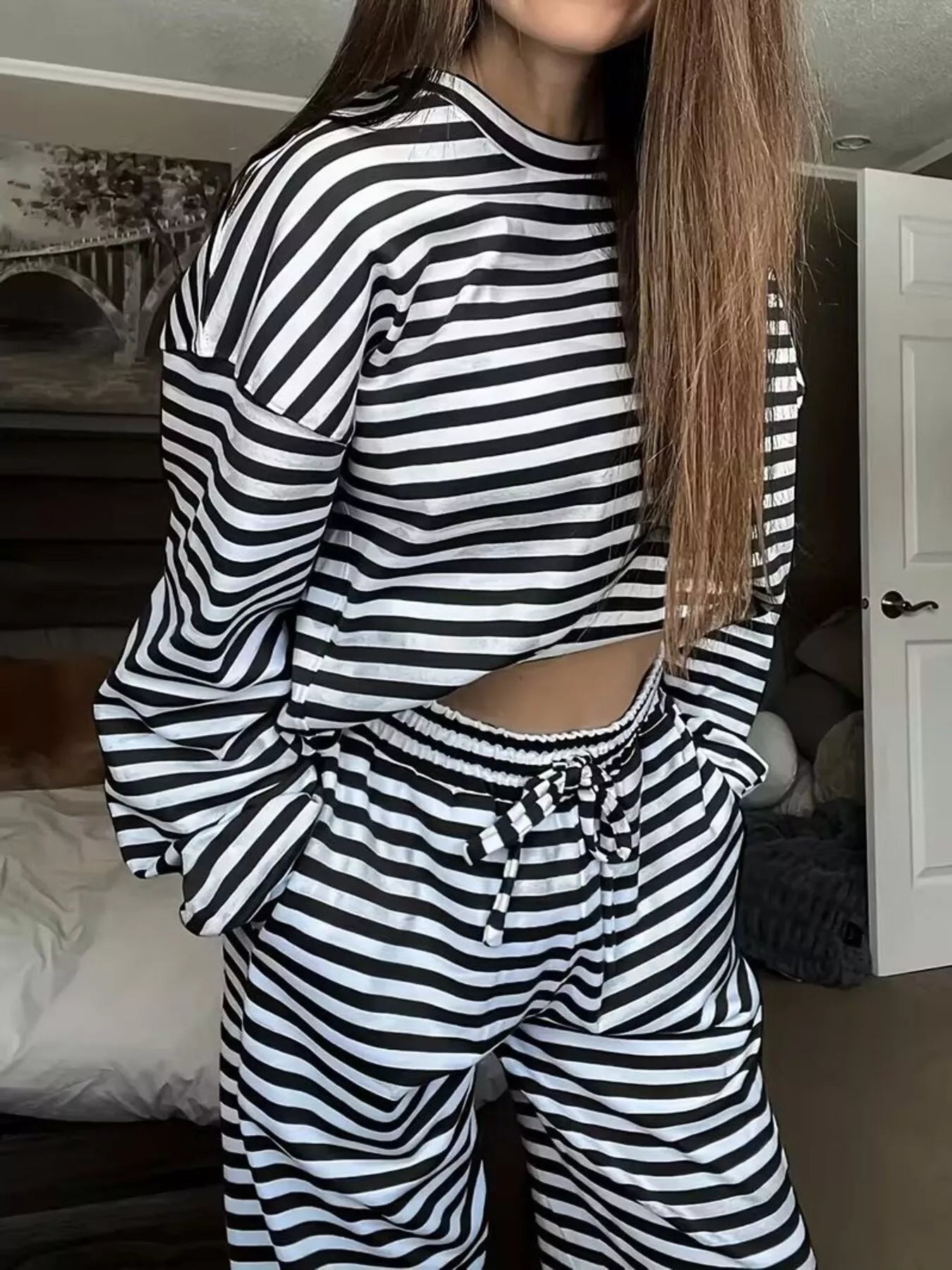 Person wearing a black and white striped outfit in a room.