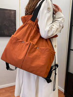 Person holding an orange drawstring bag indoors