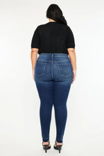 Person wearing blue jeans and a black top on a white background