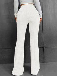White ribbed pants worn by a person against a gray background