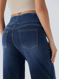 Person wearing blue jeans on a plain background