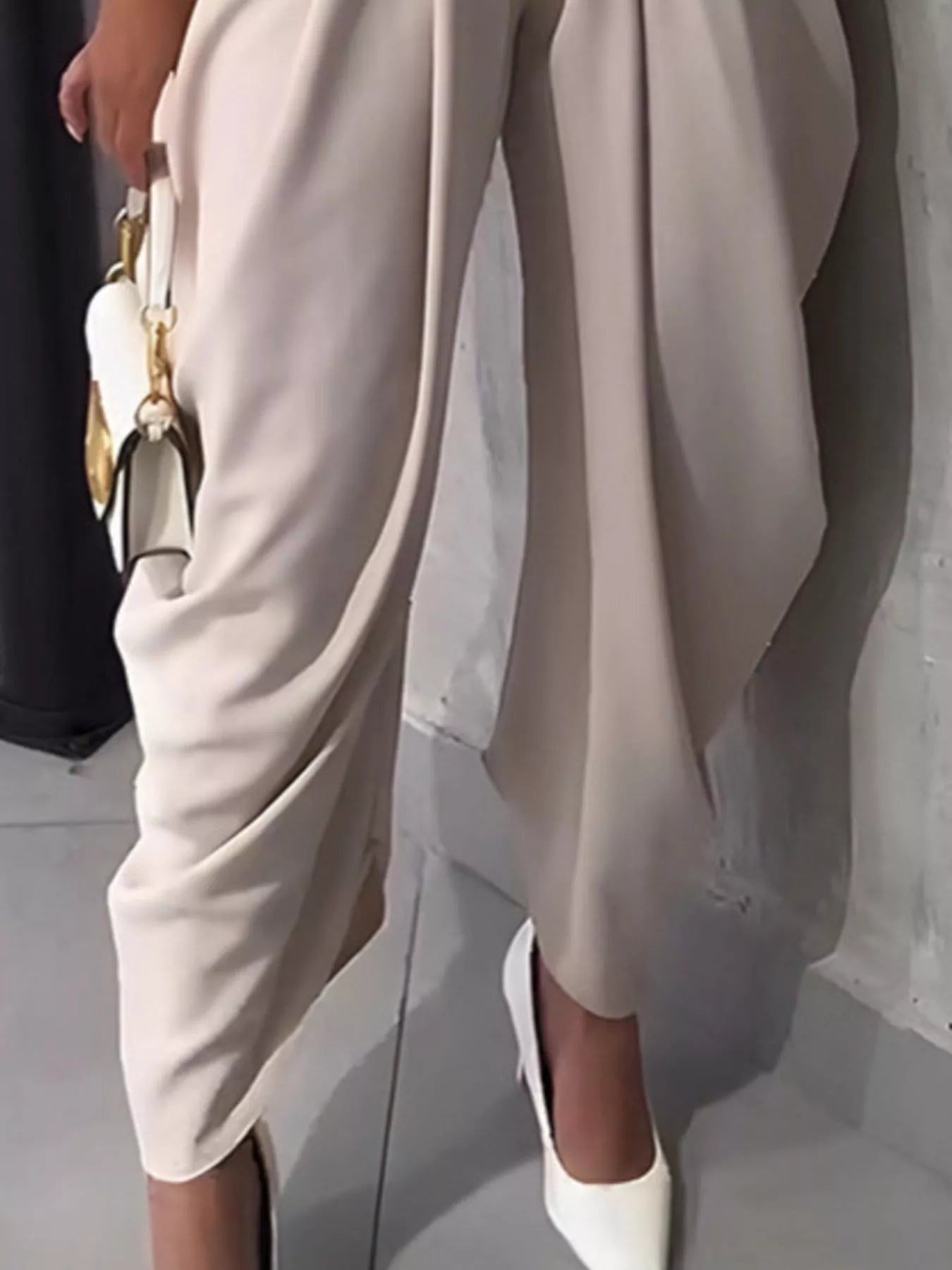 Person wearing a beige dress with a plain background