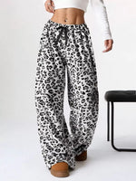 Leopard print pants worn by a person on a white background